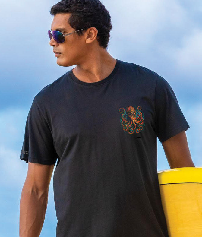 Man facing camera wearing a black t-shirt with a small colorful octopus logo on chest. View 3
