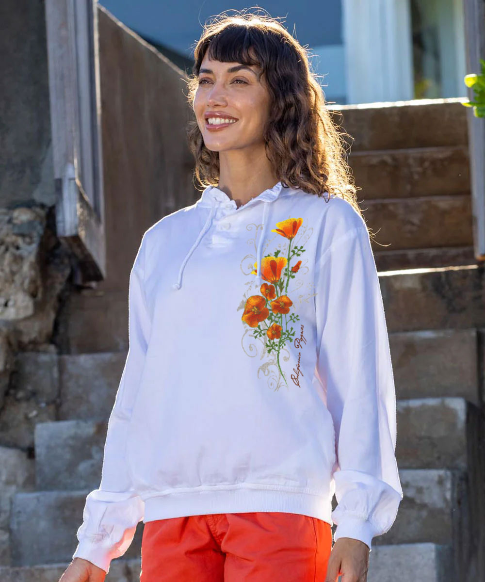 Woman wearing a white long sleeve pullover with floral design outdoors View 2