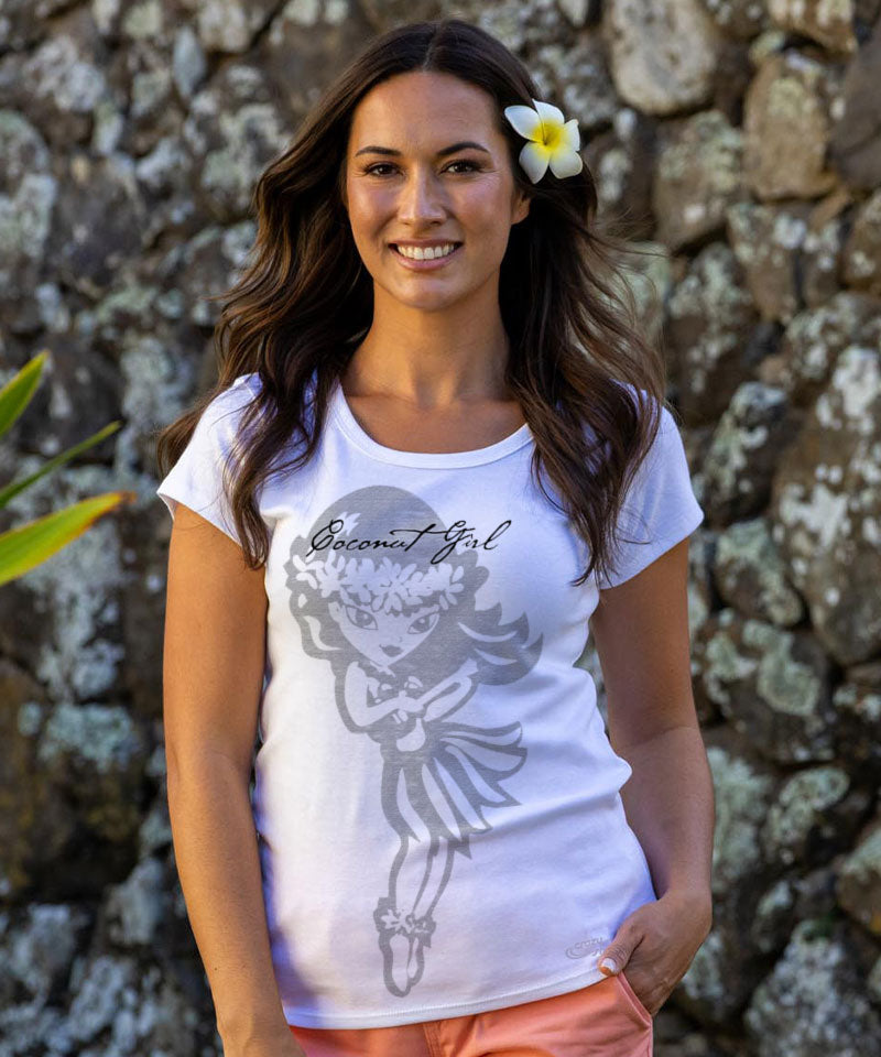 Woman wearing a white t-shirt with a graphic design and text, standing against a stone wall. View 2