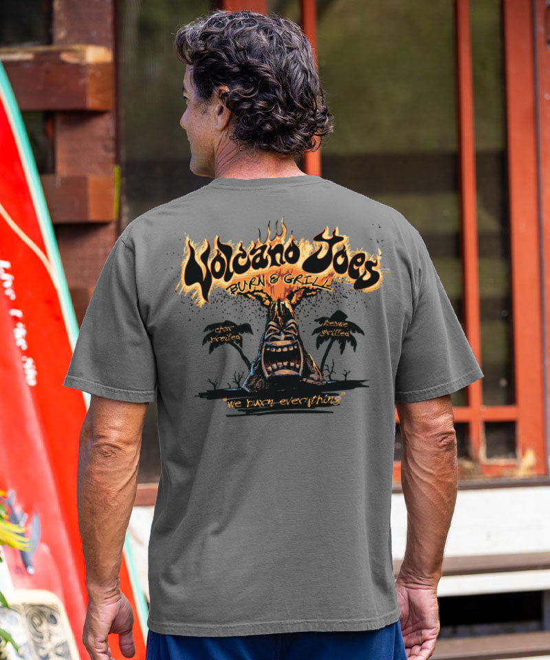 Man wearing a gray t-shirt with a graphic design on the back, standing outdoors. View 2