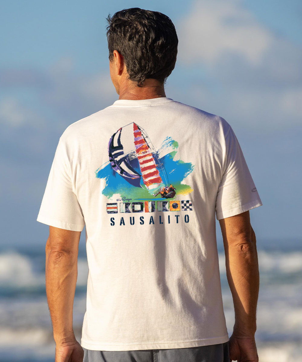 Man wearing a white t-shirt with a colorful graphic on the beach View 2