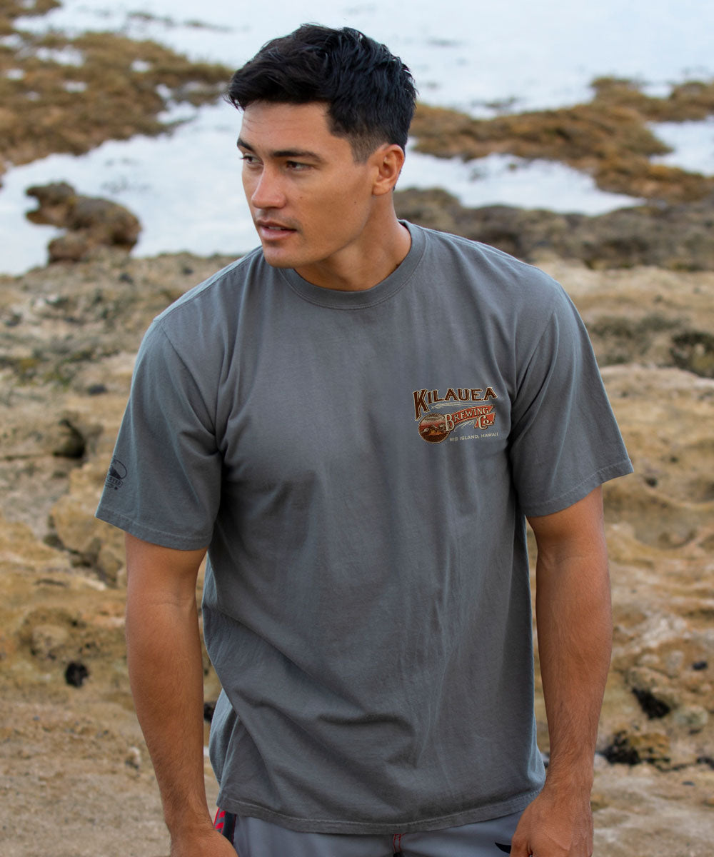 Man wearing a gray t-shirt with a logo on a rocky beach View 3