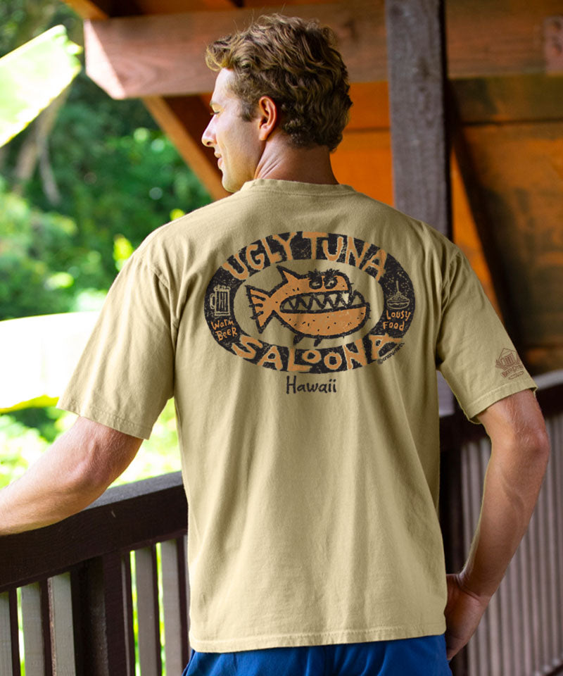 Man wearing a beige t-shirt with a graphic design on the back, standing on a wooden deck. View 2