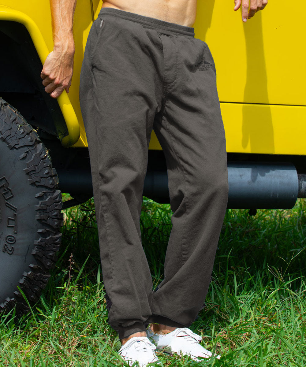 A person standing in front of a yellow vehicle wearing gray pants View 2