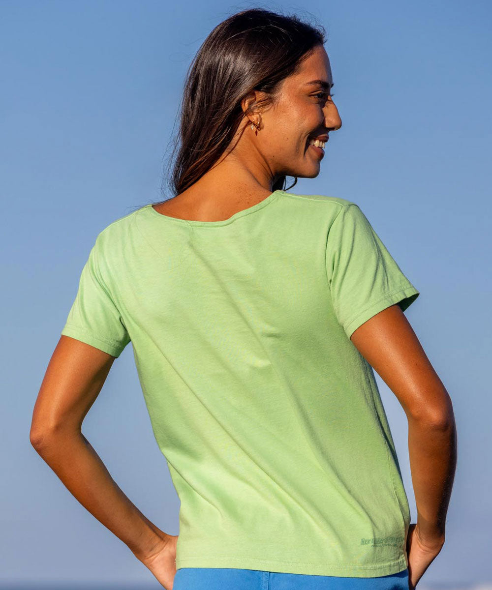 Woman wearing a green t-shirt against a clear blue sky View 3