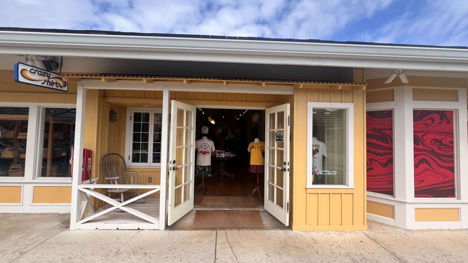 Coconut Marketplace Kauia storefront with open doors, people inside, and a clear sky.