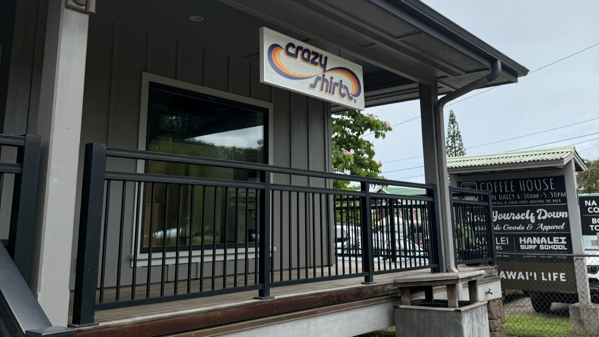Building exterior with a sign that reads 'crazy things' on a cloudy day.