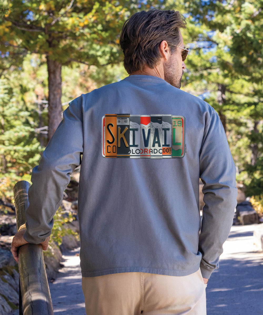 A person facing away from the camera wears a long sleeve crewneck t-shirt with a 'SKIVN' logo and text on the back. View 2