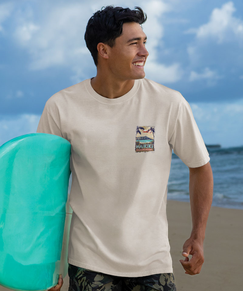 Man holding a teal surfboard on a beach with a scenic t-shirt View 3