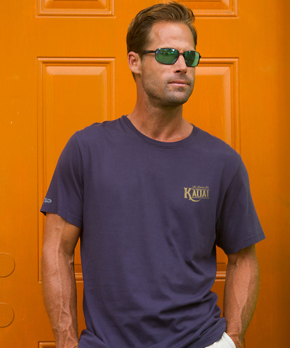 Man wearing sunglasses and a dark blue t-shirt against an orange background. View 3