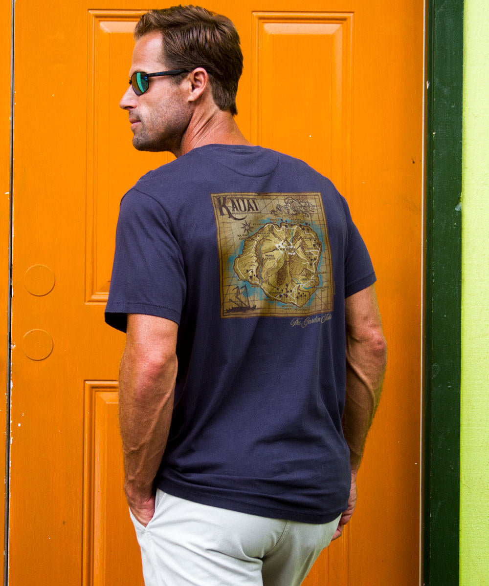 Man wearing a navy blue t-shirt with a map design, standing in front of an orange door. View 2