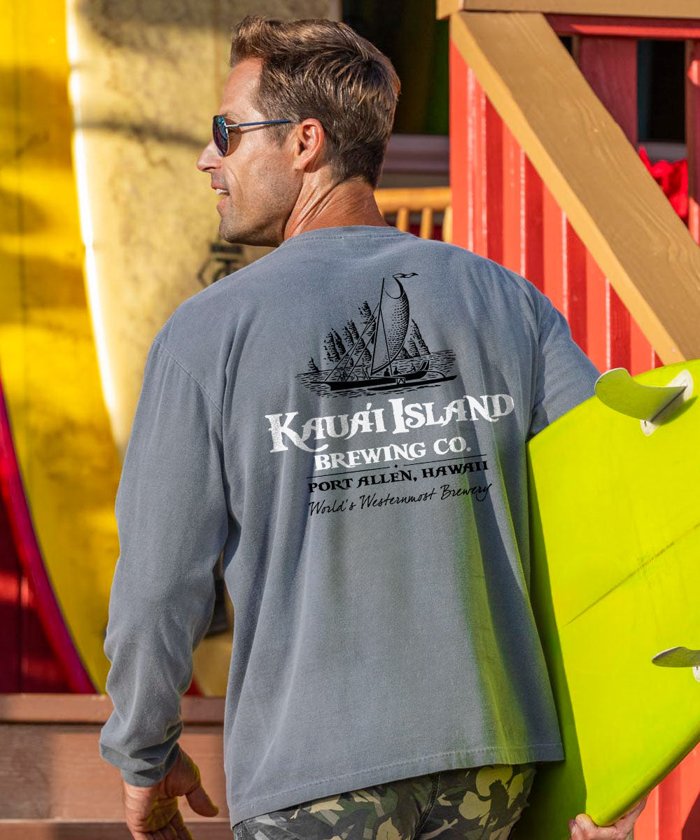 Man wearing a gray t-shirt with Kauai Island Brewing Co. logo, holding a yellow surfboard. View 2