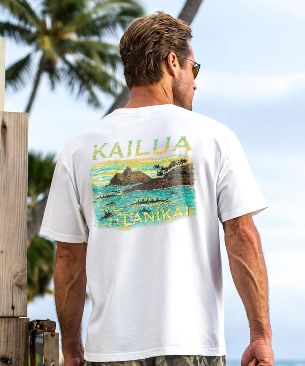 Man wearing a white t-shirt with a scenic design and text, standing outdoors with palm trees and blue sky. View 2