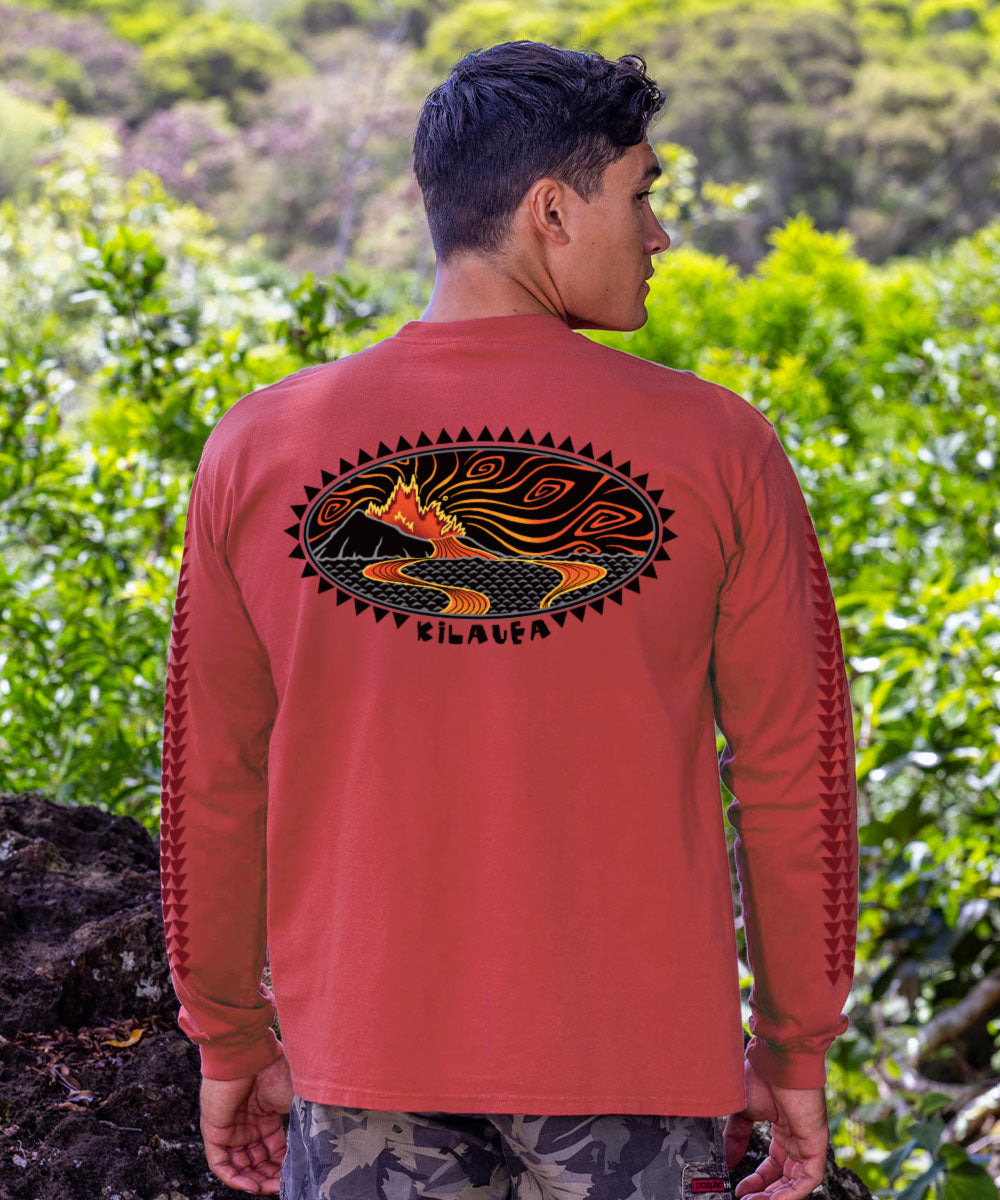 Man in red long sleeve shirt with graphic design standing in front of rocks and greenery View 2