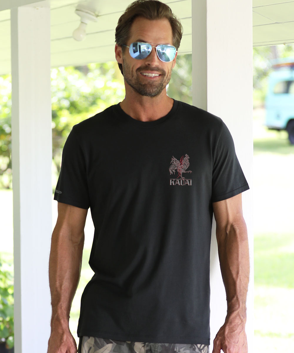 Man wearing a black t-shirt with a logo and text, standing outdoors. View 3