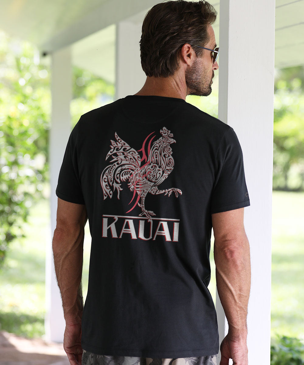 Man wearing a black t-shirt with a rooster design and 'Kauai' text, standing outdoors. View 2