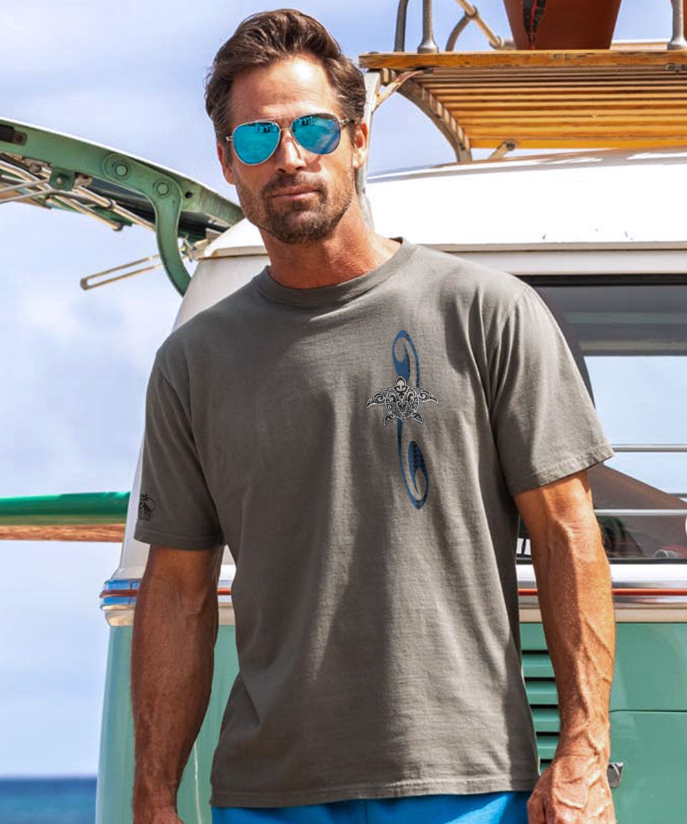 Man wearing a gray t-shirt with a logo, standing in front of a vintage van on a sunny day. View 3
