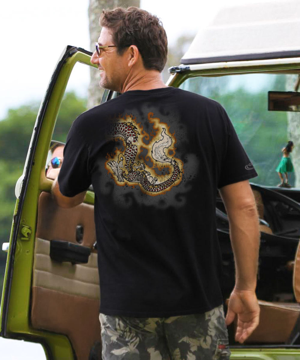 Man wearing a black t-shirt with a dragon design, standing next to a vehicle. View 3