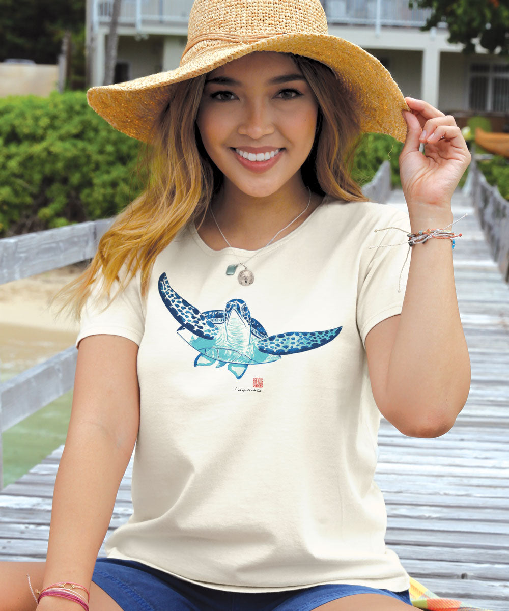 Woman sitting on a doc wearing a tan scoop neck with a turtle design on the front View 2