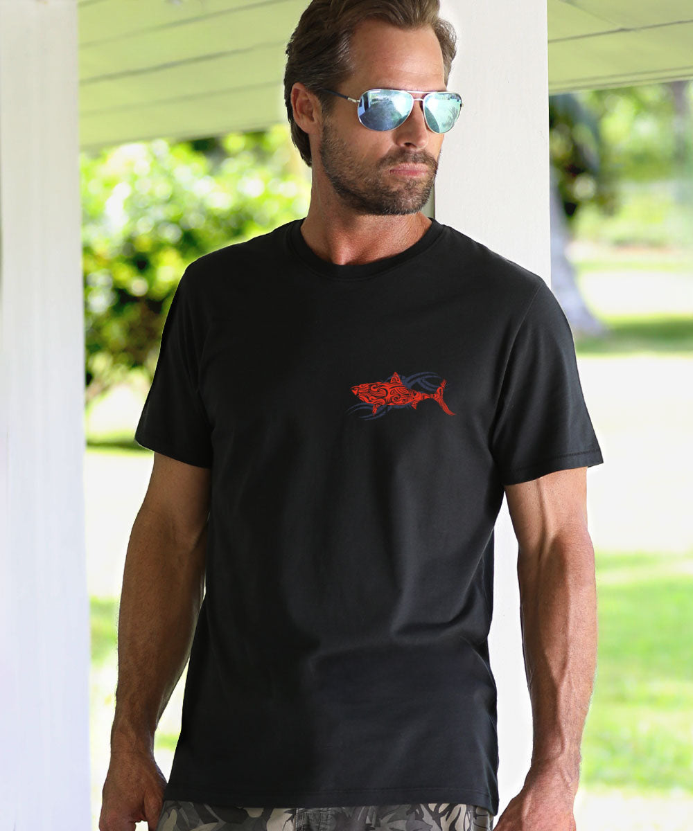 Man wearing a black t-shirt with a red shark and grey graphic design outdoors. View 3
