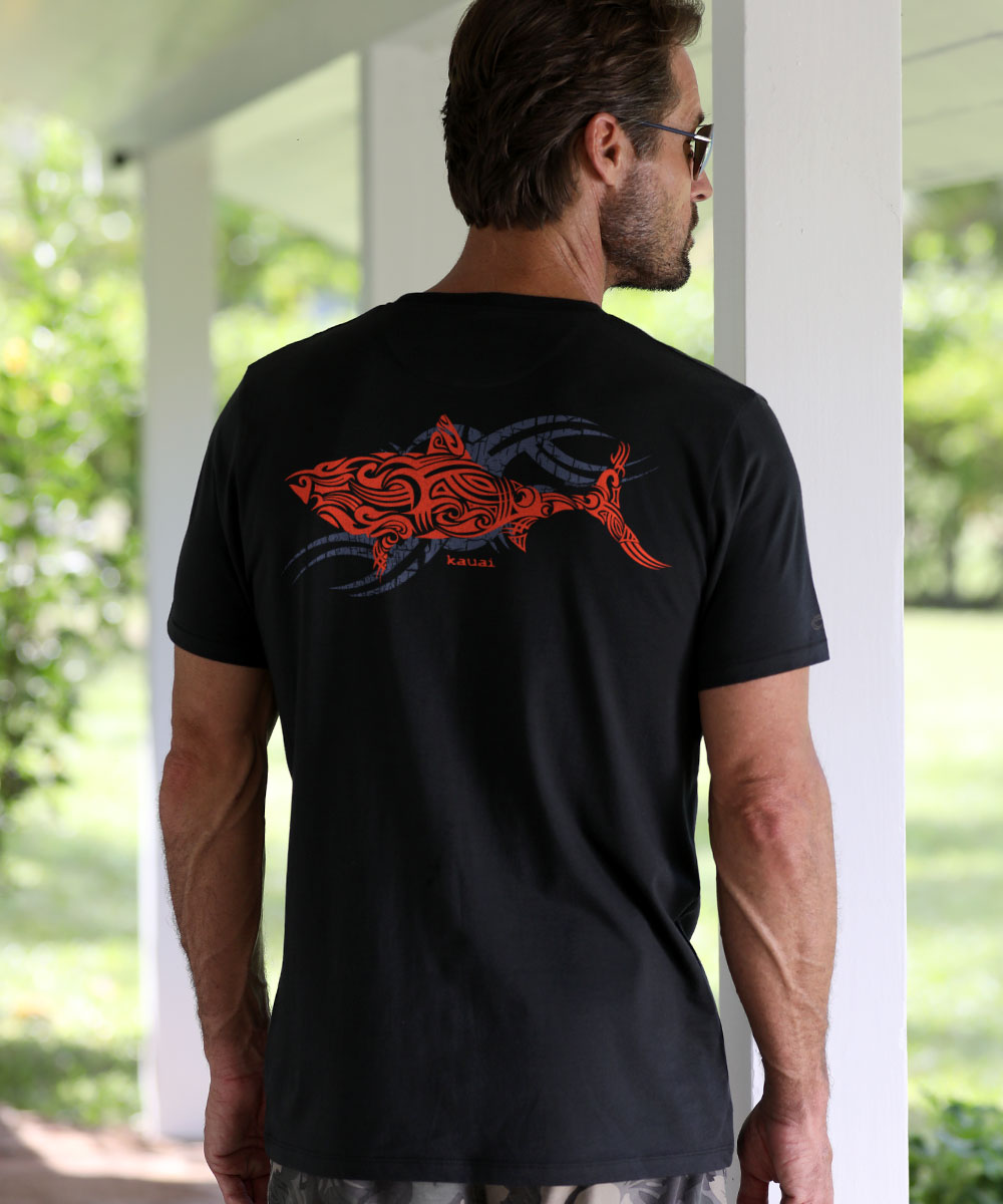 Man wearing a black t-shirt with a red shark and grey graphic design outdoors. View 2