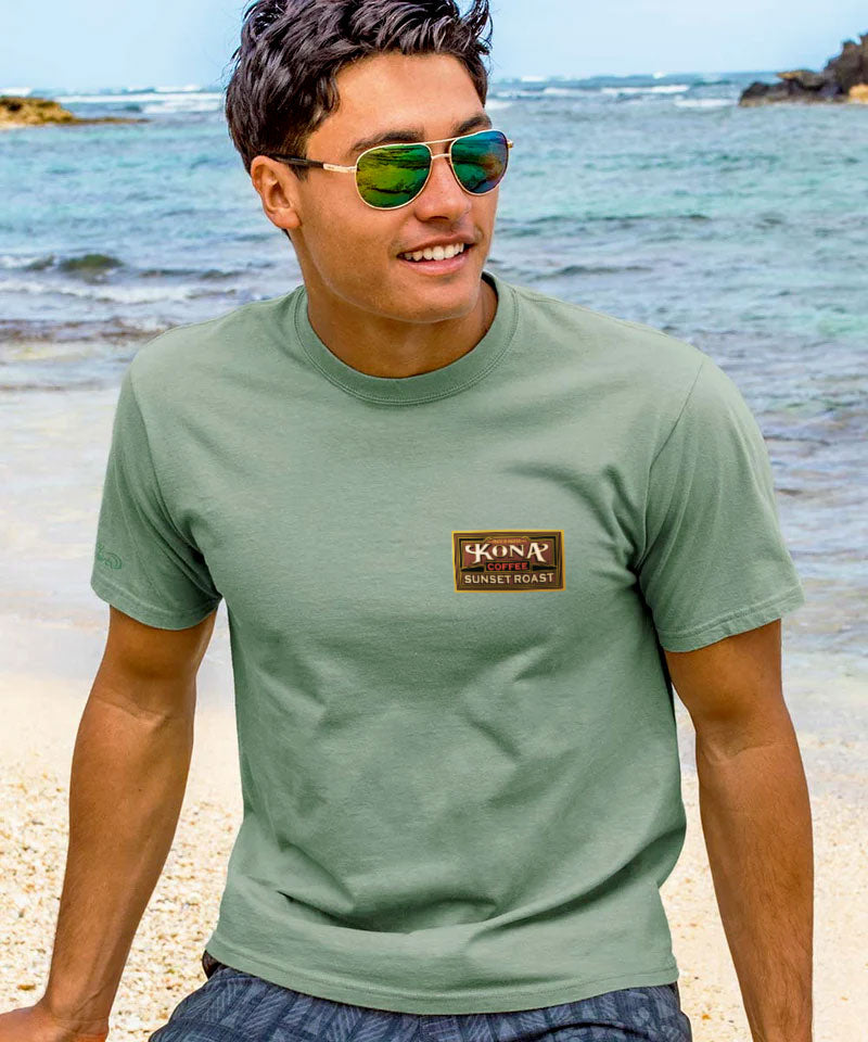 Man wearing a green t-shirt with a logo on a beach View 3