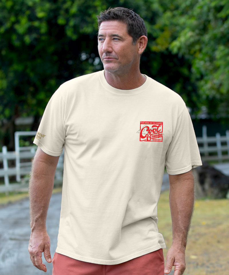 Man wearing a beige t-shirt with a small red logo on chest looking out at the view View 3