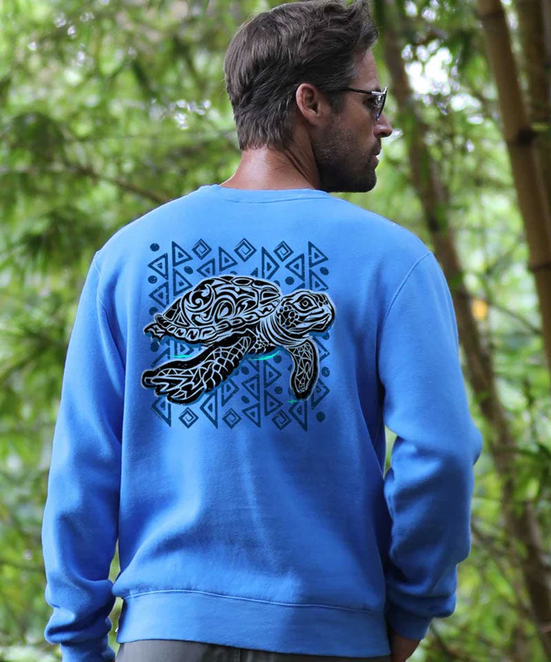 Man wearing a blue sweatshirt with a turtle design in a forest setting View 3