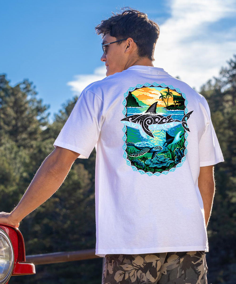 A person wearing a white short sleeve crewneck t-shirt with a graphic design of a shark and tribal artwork on the back. View 2