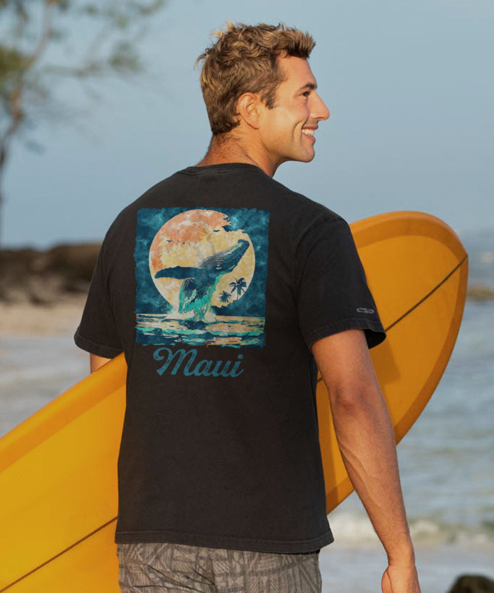 A man standing on a beach wearing a black short sleeve crewneck t-shirt with a graphic of a whale and the word 'Maui' on it. View 2