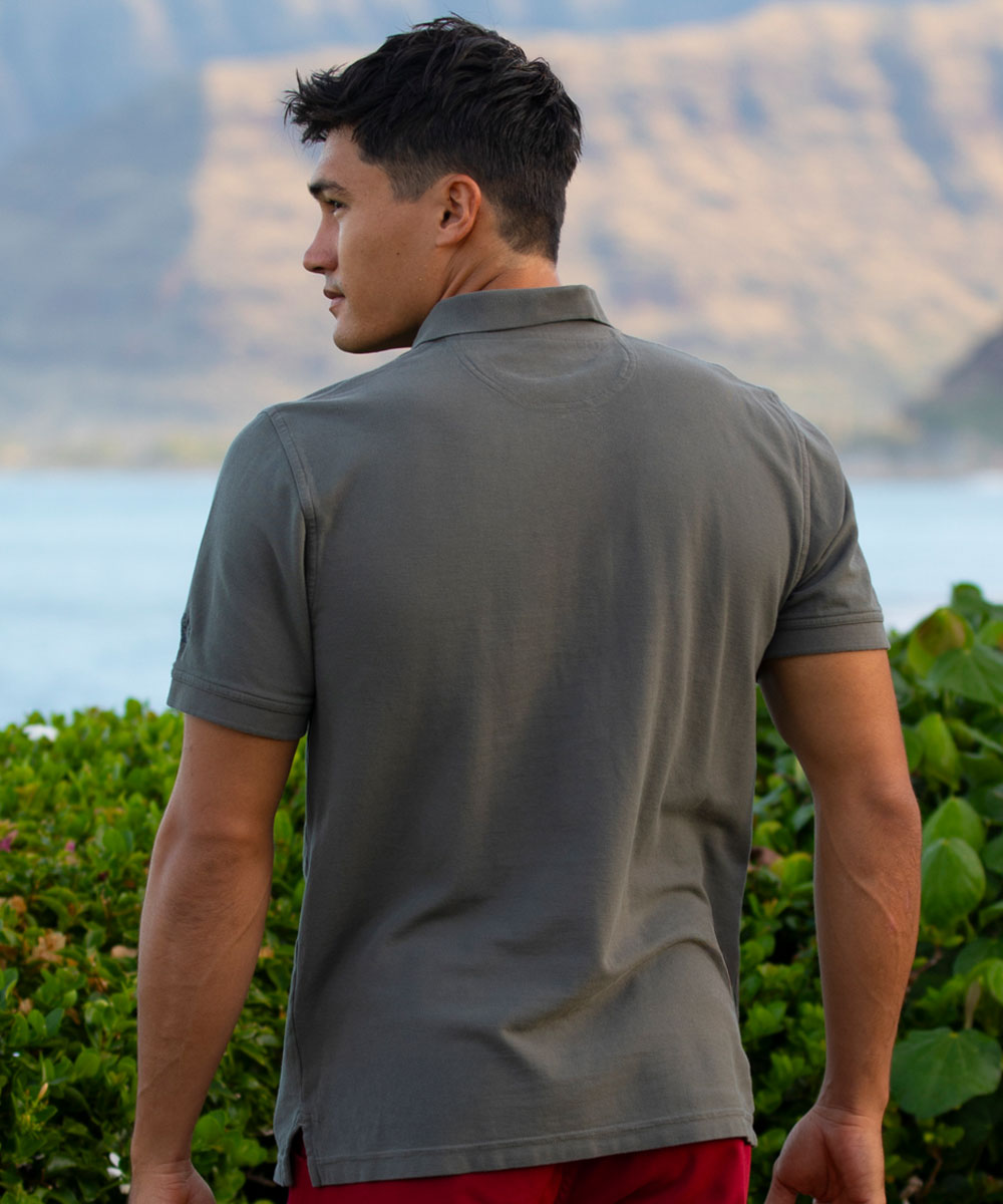 Man wearing a gray polo shirt with a scenic background of mountains and water. View 3