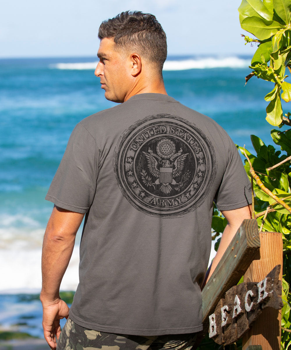 Man wearing a gray shirt with a graphic on the back in front of the beack View 2