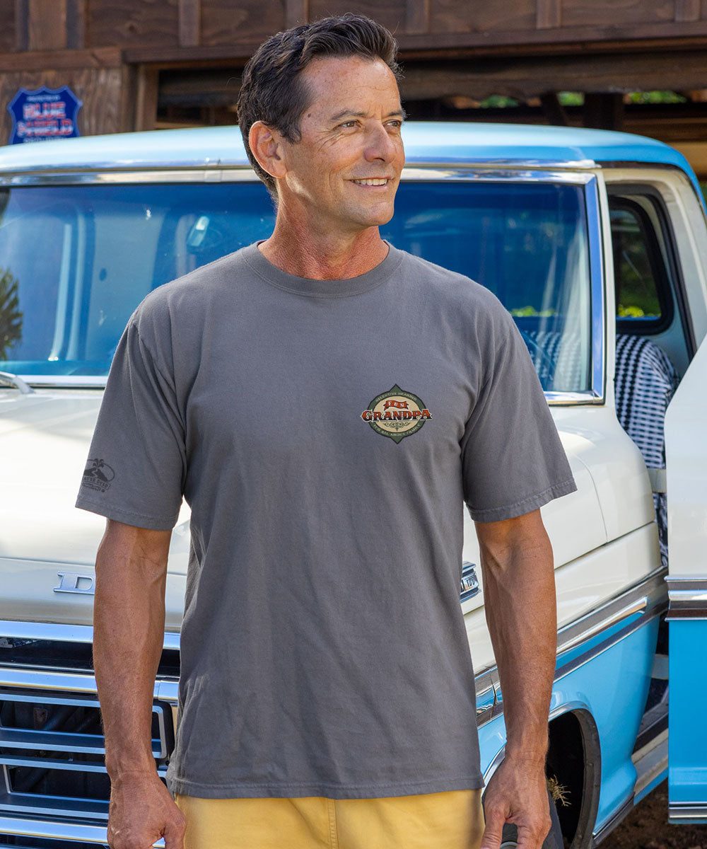 Man in a gray shirt standing in front of a truck View 3