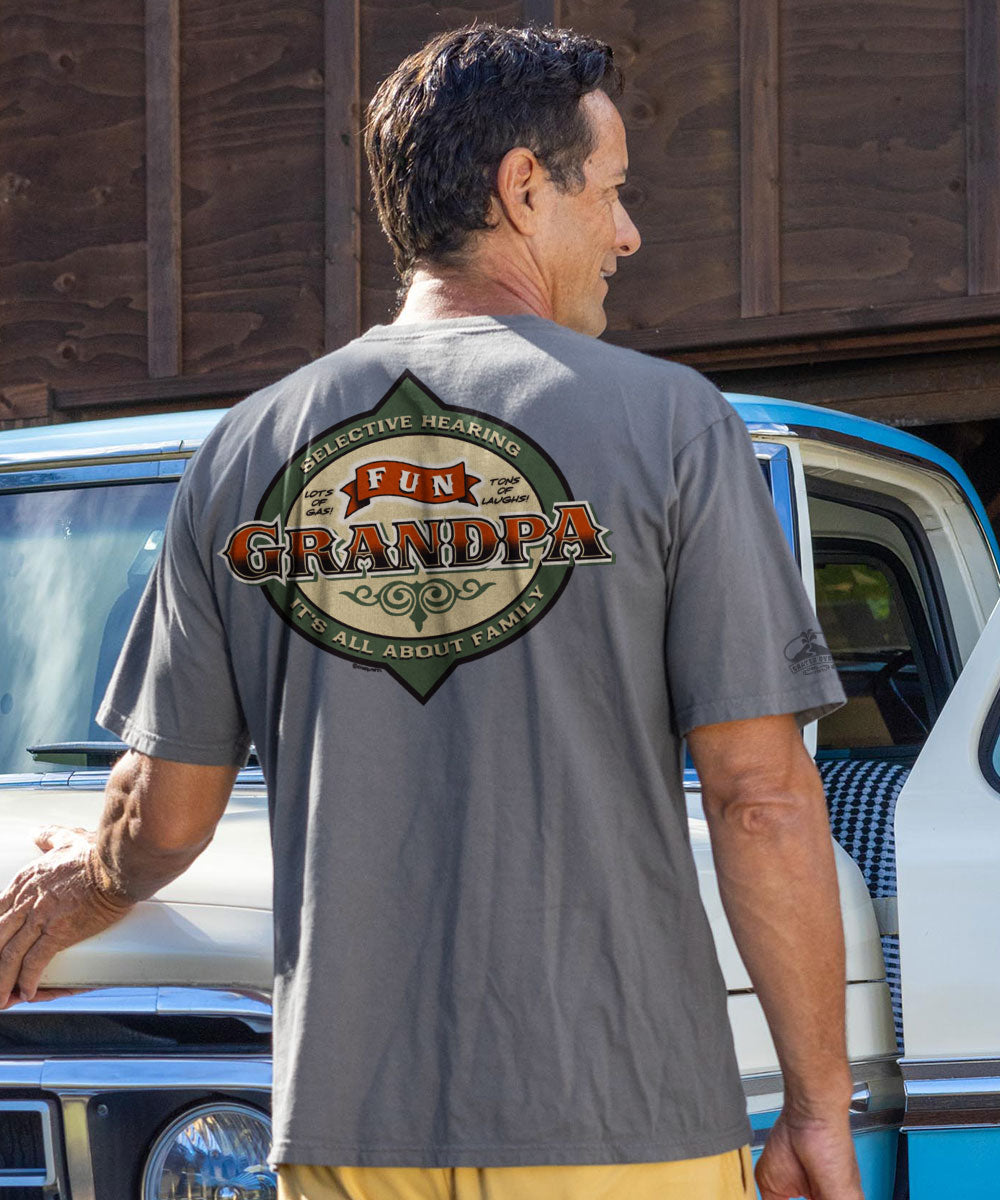 Man in a gray shirt standing by an old truck View 2