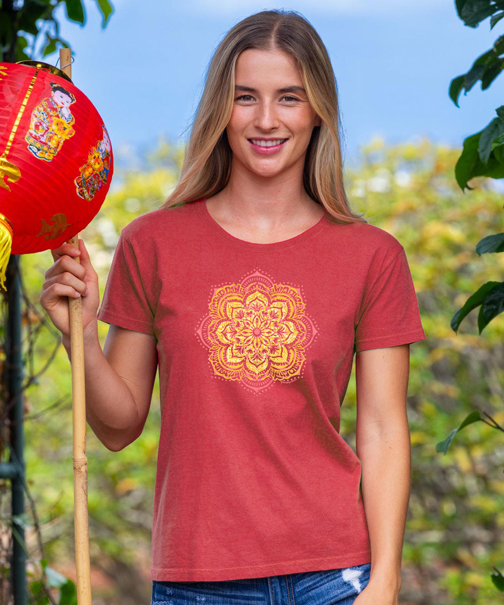 Woman wearing a red t-shirt with a yellow floral design, holding a red lantern outdoors. View 2