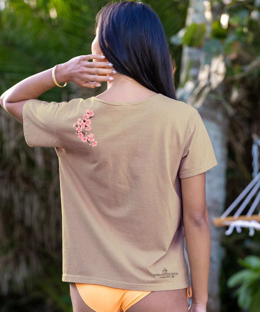 Woman wearing a beige t-shirt with cherry blossom design in a natural setting View 3