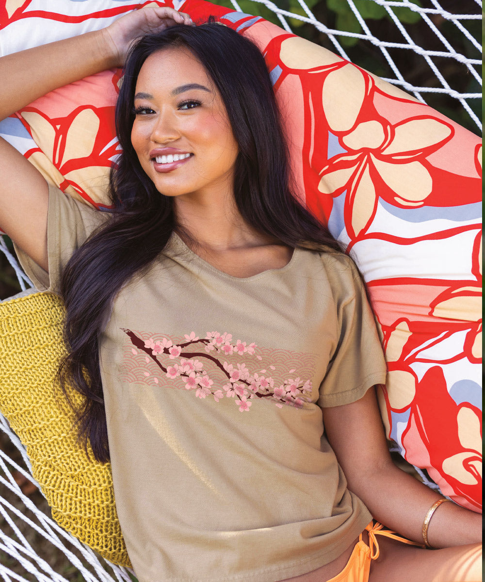 Woman wearing a beige t-shirt with cherry blossom design in a natural setting View 2