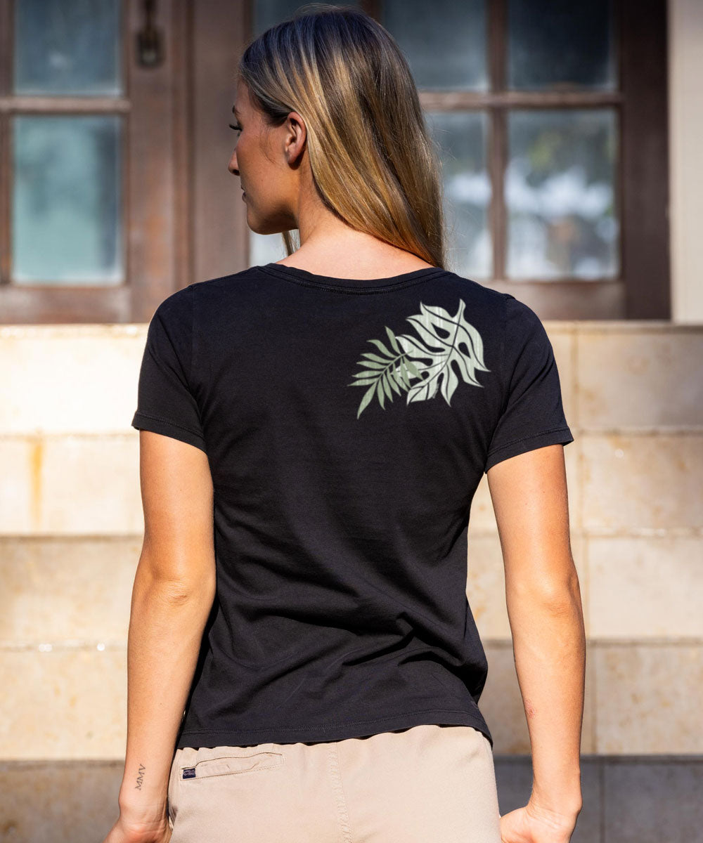 A woman wearing a black short sleeve pima V-neck t-shirt with a leaf design on the front. View 3