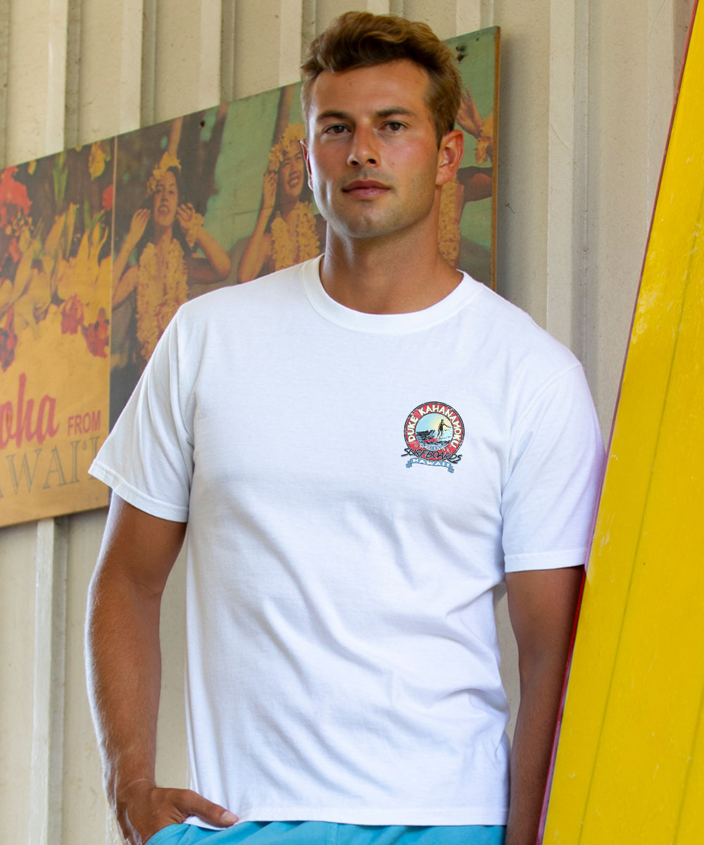 Man wearing a white t-shirt with a logo, standing in front of colorful wall art. View 3