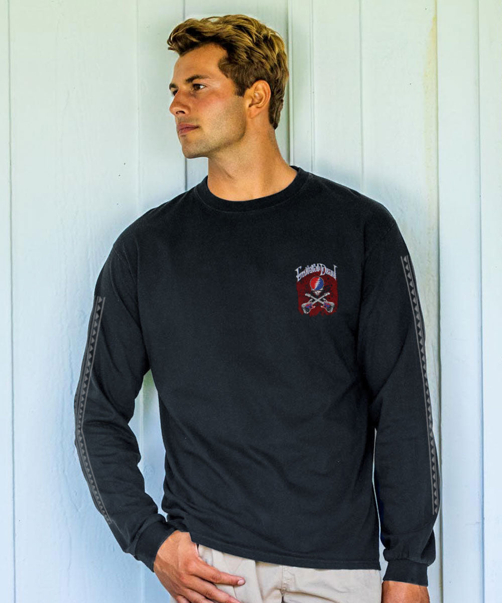 Man wearing a black long-sleeve shirt with a Grateful Dead pocket logo standing against a wall. View 3