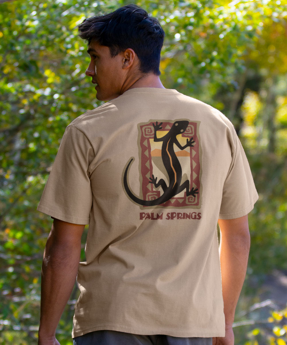 Man wearing a beige t-shirt with a lizard design and 'Palm Springs' text outdoors. View 2