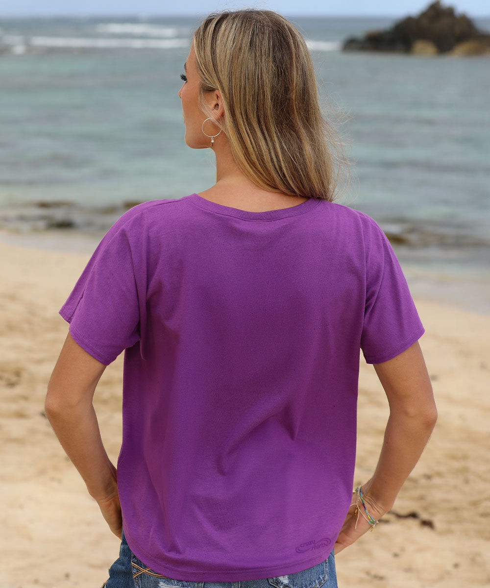 Person wearing a purple t-shirt on a beach View 3