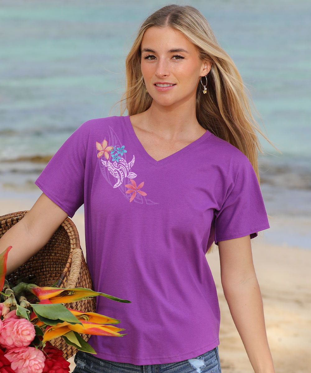 Woman wearing a purple t-shirt with floral designs on a beach View 2