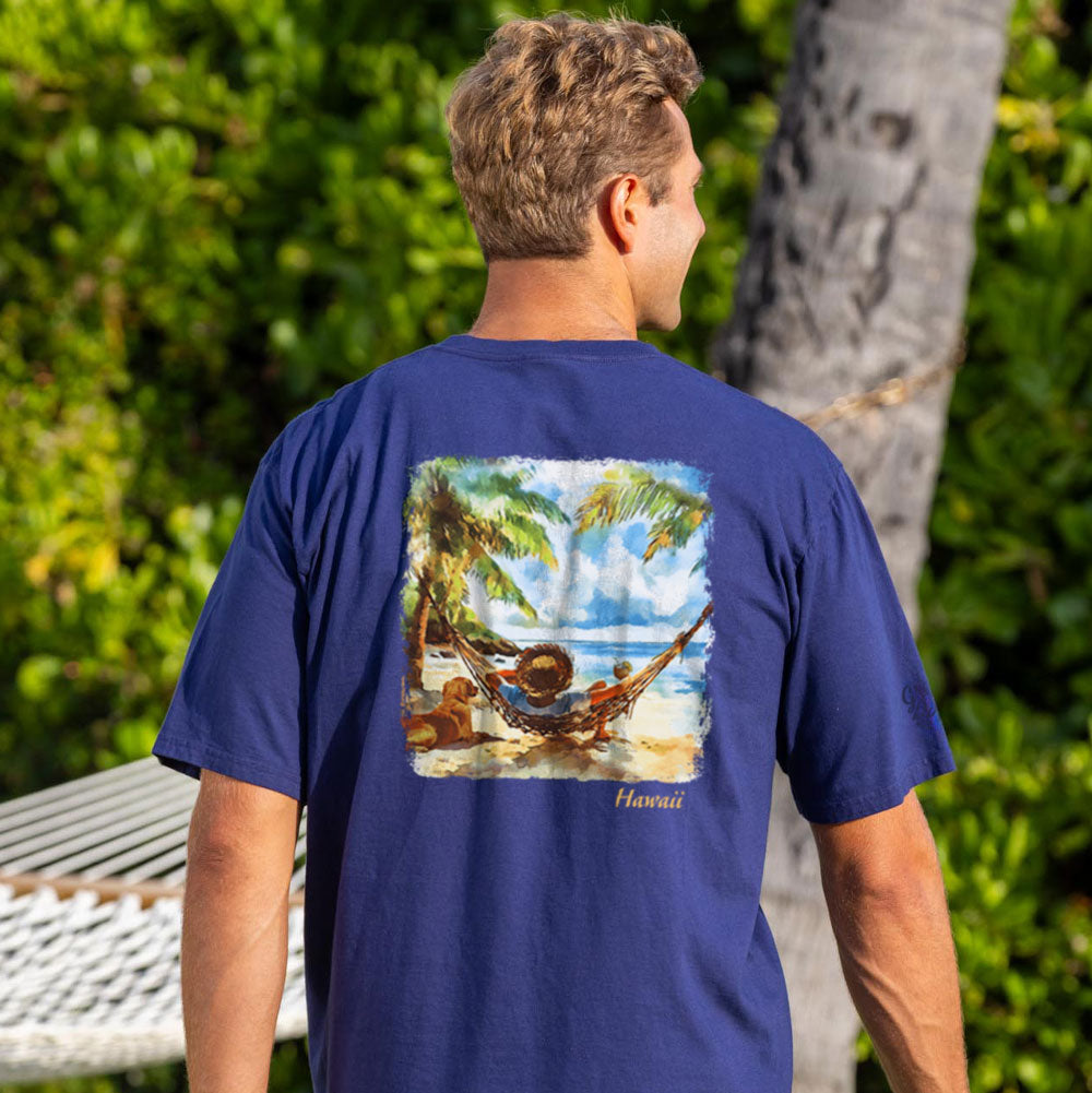Man wearing a navy blue t-shirt with a tropical beach graphic on the back, standing outdoors.