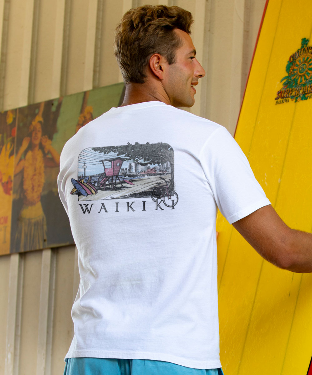 Man wearing a white t-shirt with 'Waikiki' design, holding a yellow surfboard. View 2