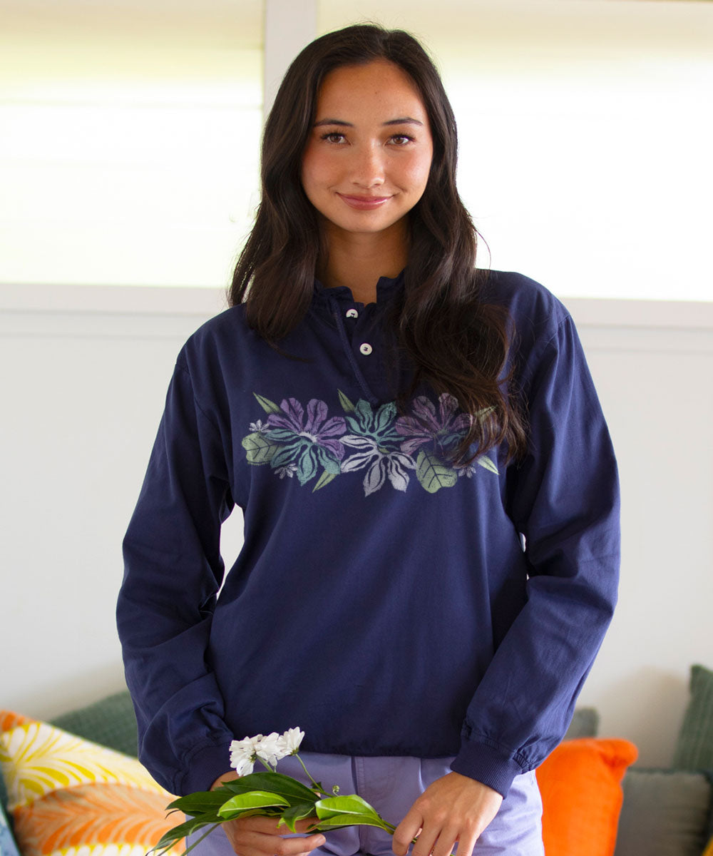Woman wearing a navy blue sweatshirt with floral design, holding flowers indoors. View 2