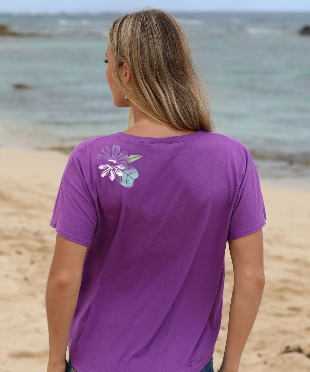 Woman wearing a purple t-shirt with a floral design on the beach View 3