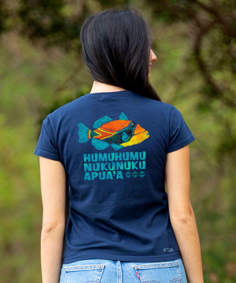 Person wearing a navy blue t-shirt with a colorful fish design and text on the back, standing outdoors. View 2