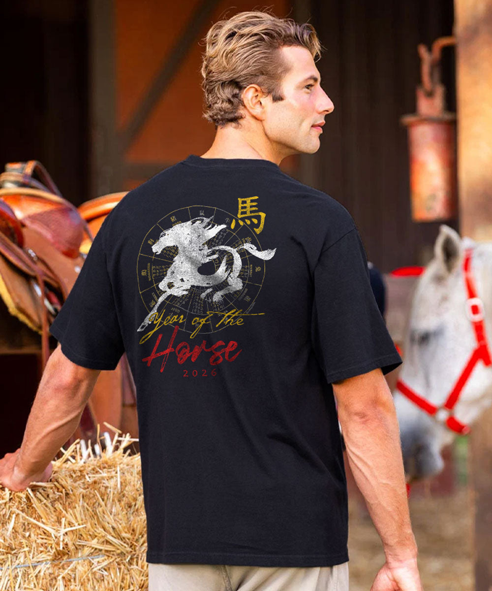 Man wearing a black t-shirt with a horse graphic and text, standing in a barn setting. View 2