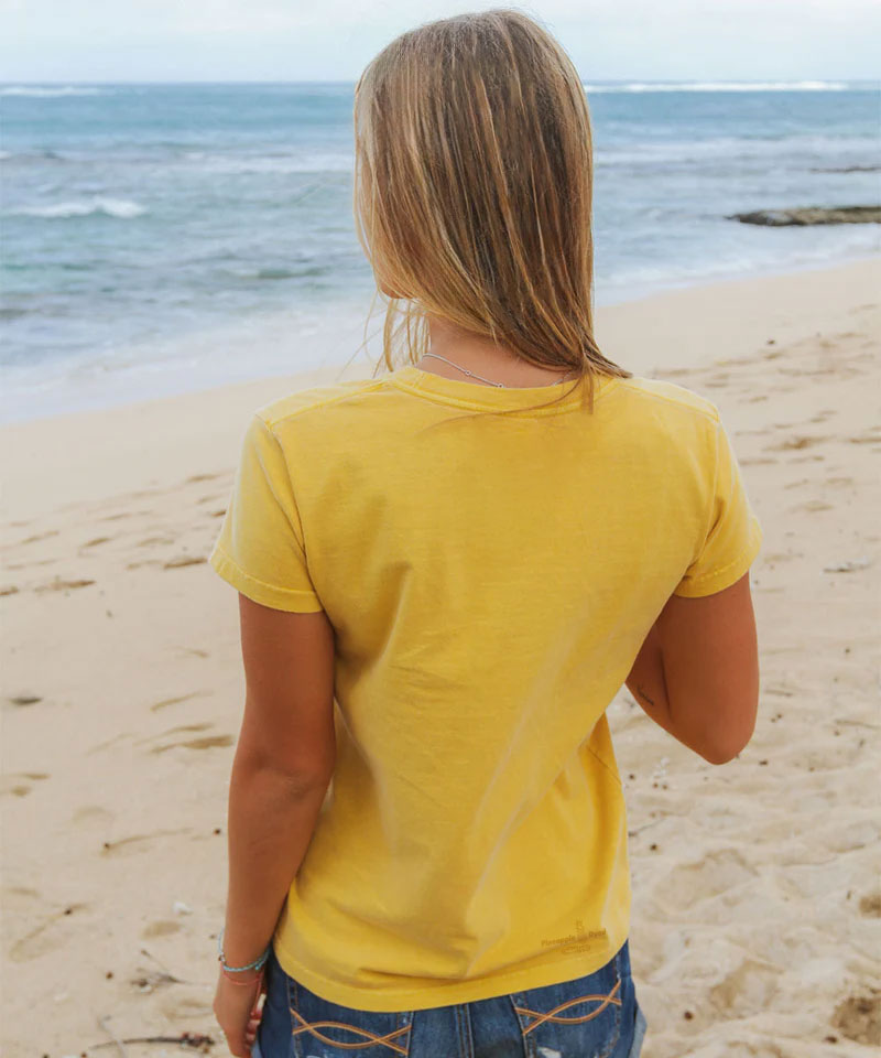 Person wearing a yellow t-shirt on a beach View 3